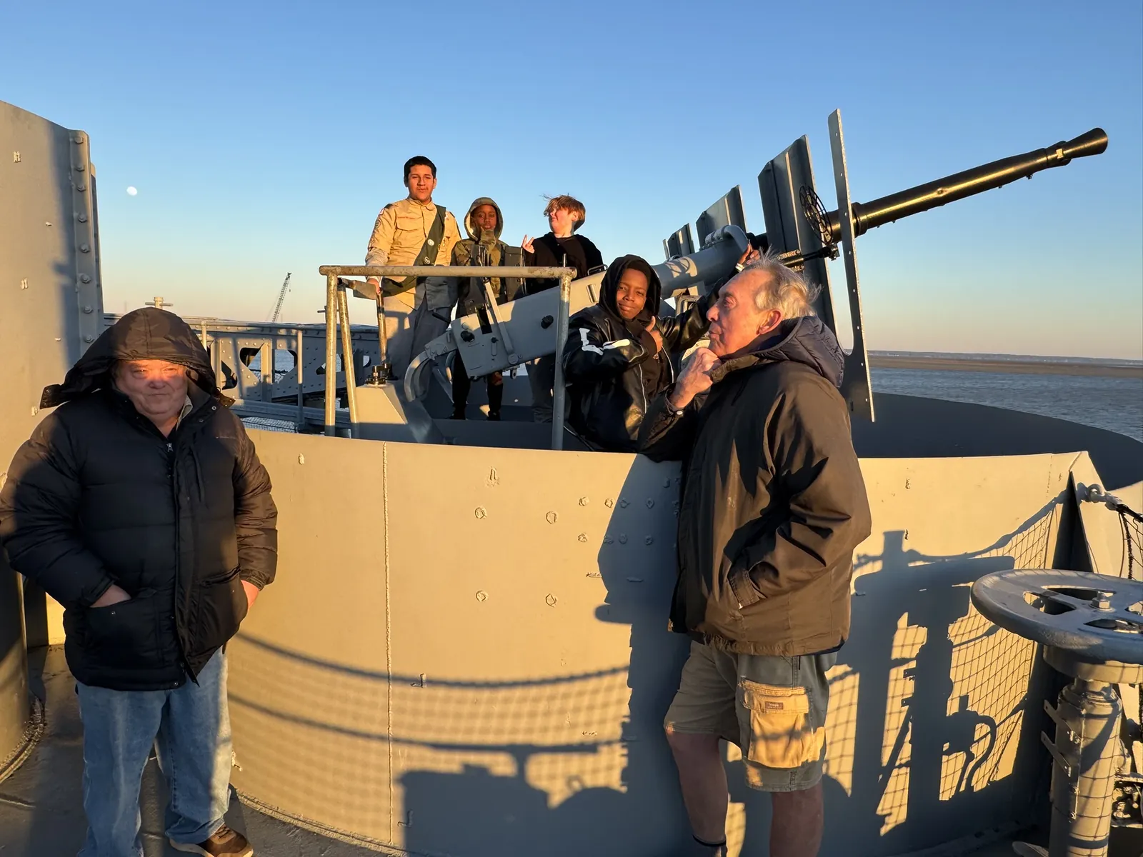 Troop 62 Scouts and leaders on the deck of the USS Alabama at sunset.
